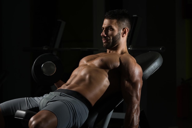 Healthy Man Working Out Biceps In A Dark Gym  Dumbbell Concentration Curls