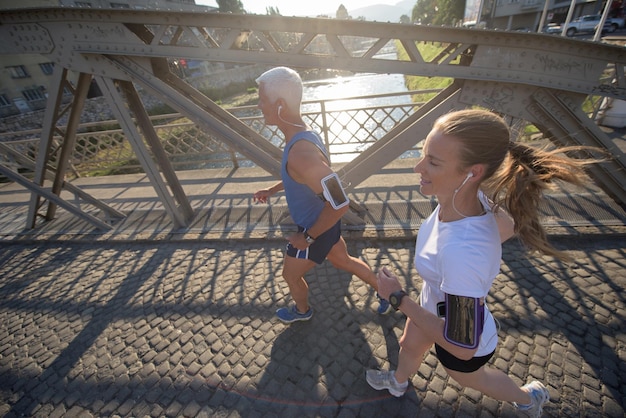 healthy mature couple jogging in the city  at early morning with sunrise in background