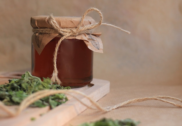 healthy mint syrup in a glass jar on a beige background with dry mint leaves