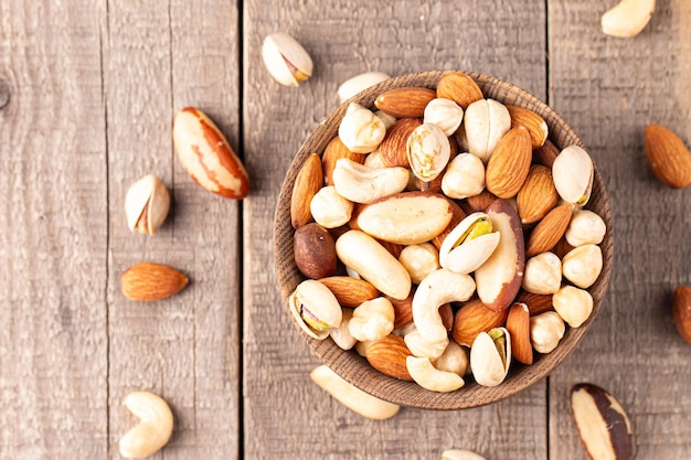 Healthy mix nuts on wooden background Almonds hazelnuts cashews peanuts pistachios