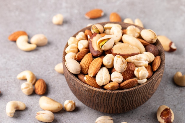 Healthy mix nuts on wooden background Almonds hazelnuts cashews peanuts pistachios