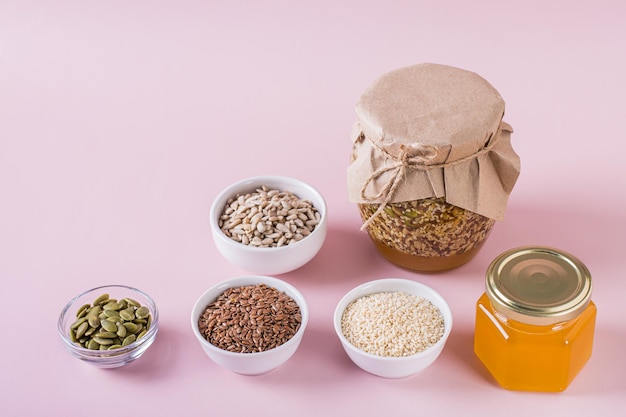 Healthy mixture of honey and various seeds in a jar and ingredients for cooking