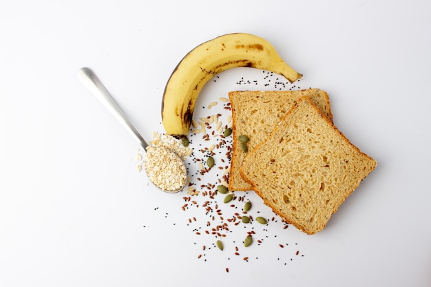 Healthy multigrain bread with pumpkin chia flax seeds banana black coffee and oats spoon