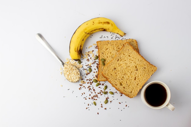 Healthy multigrain bread with pumpkin chia flax seeds banana black coffee and oats spoon