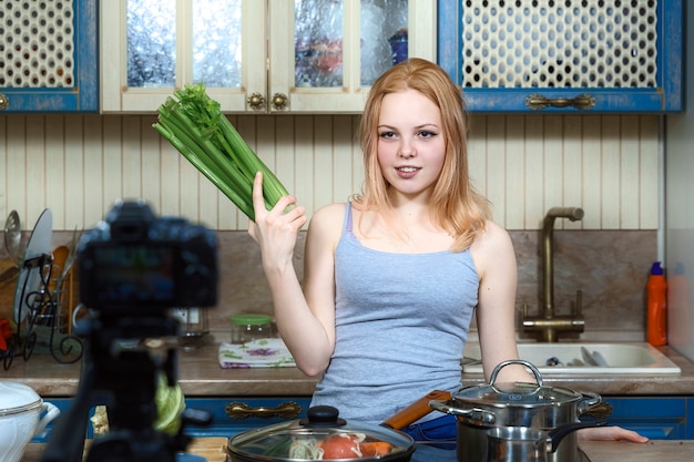 Photo healthy nutrition blog. girl cooking vegetable salad, recording video at home kitchen