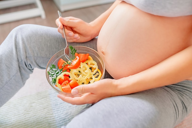 Healthy nutrition and pregnancy. pregnant woman's belly and vegetable salad