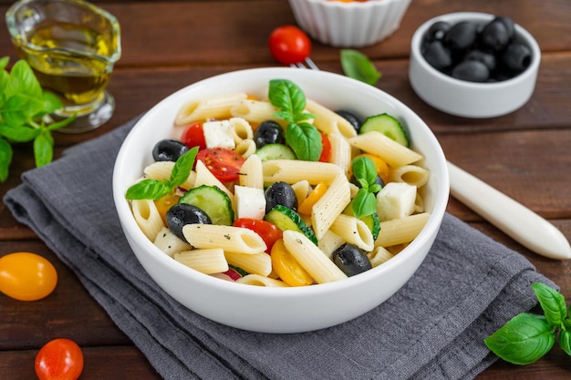 Healthy pasta salad with tomatoes cucumbers red onions olives and cheese  Copy space