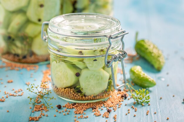 Healthy pickled cucumber in jar with herbs