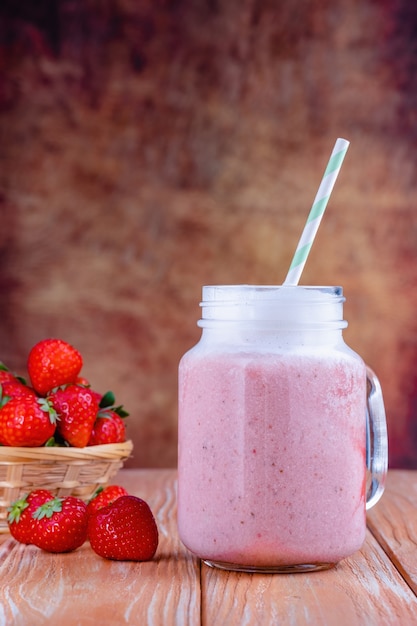 Healthy pink smoothie with strawberry in glass jars