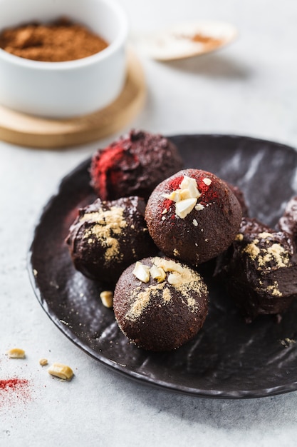 Healthy raw energy balls with cocoa, dates, maca, chia on white background.