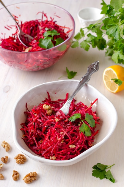 Healthy raw vegan beetroot salad with carrot and walnuts in a bowl 