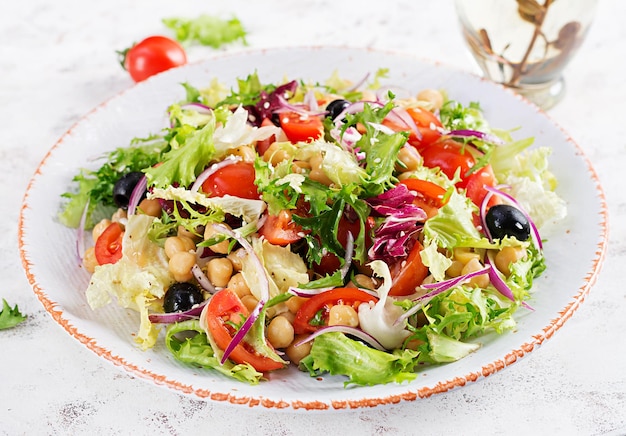 Healthy salad of chickpeas tomatoes olives and lettuce with red onion Healthy food diet Closeup food