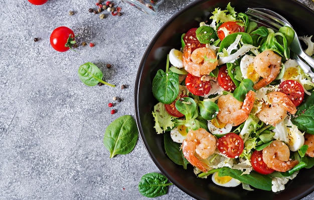 Healthy salad plate. Fresh seafood recipe. Grilled shrimps and fresh vegetable salad and egg. Grilled prawns.