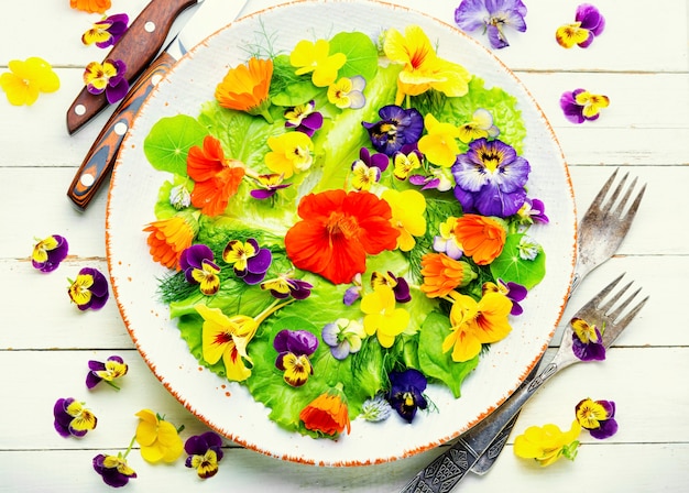 Healthy salad with green lettuce and edible flowers.Fresh summer salad with flowers