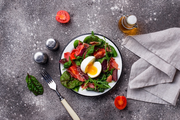 Healthy salad with prosciutto, tomato and egg