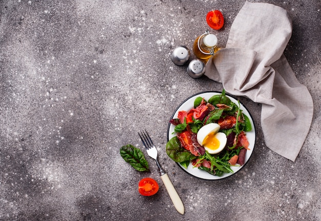 Healthy salad with prosciutto, tomato and egg