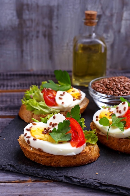 Healthy sandwich with mozzarella, tomato, eggs and flax-seed