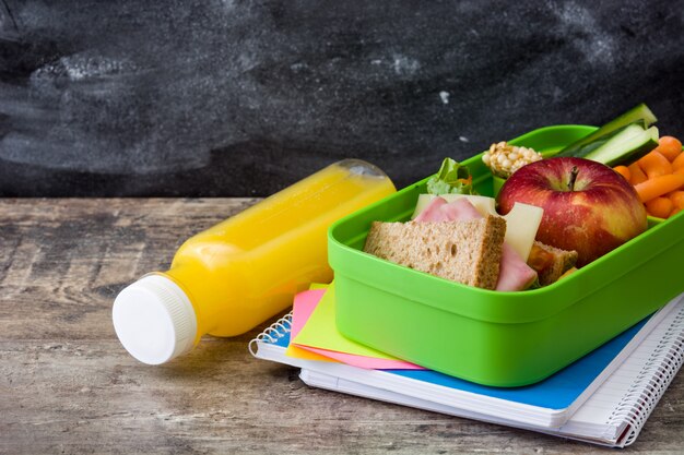 Healthy school lunch Sandwich, vegetables ,fruit and juice on wooden table, copyspace