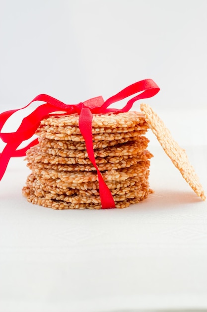 Healthy Sesame crisps cookies with red ribbon White background Copy space Isolated