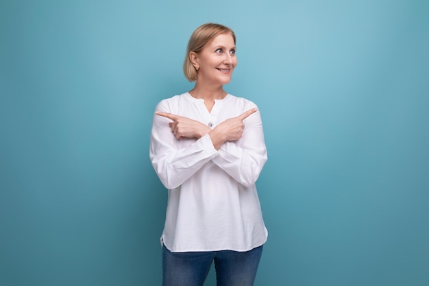 Healthy slim blond mature woman smiling on studio background