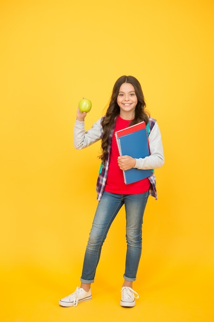 Healthy snack Happy child hold apple and books School snack Snack break Healthy eating and snacking Vegetarian food Vitamin nutrition Diet and dieting Breakfast or lunch time Eat right