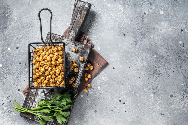 Healthy snack roasted spicy chickpeas in a basket Gray background Top view Copy space