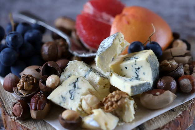 Healthy snack on a wooden tray. Cheese, nuts and fruits. Keto diet. Keto snack.