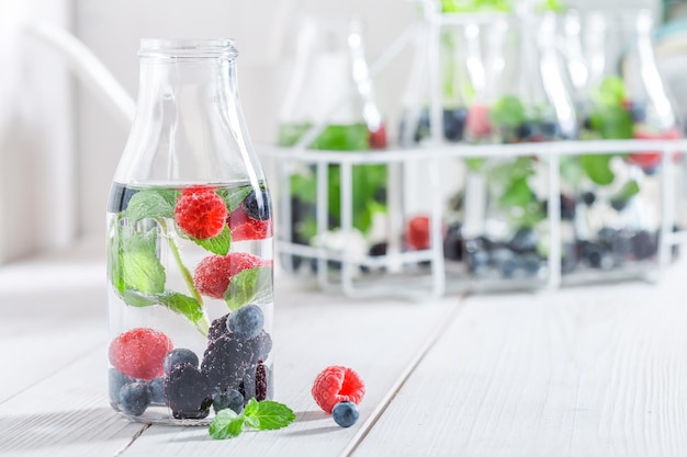 Healthy soda in bottle with raspberries blueberries and blackberries