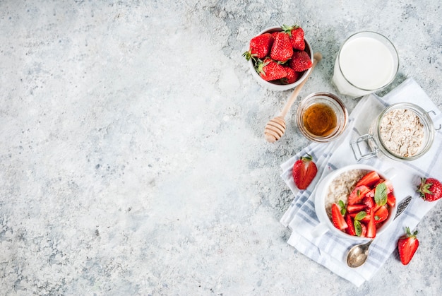 Healthy summer breakfast, overnight oatmeal with fresh strawberry and milk