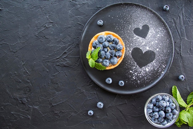 A healthy tasty dessert of cheese blueberry tart. Creative atmospheric decoration