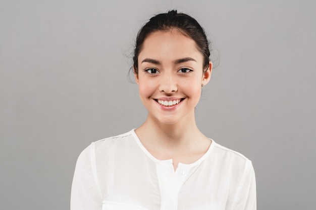 Healthy teeth smile woman clean skin natural makeup female portrait over gray background. Studio shot.