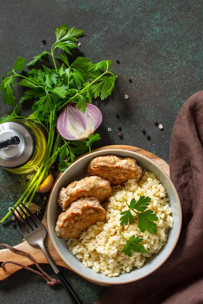 Healthy vegan food Red fish cutlets with bulgur on a dark stone or slate table Flat top view