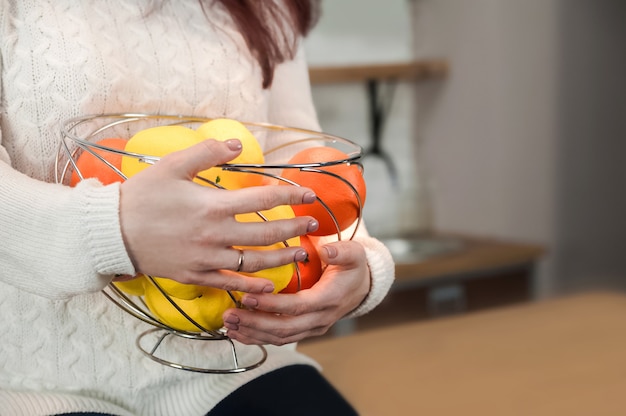 Healthy vegan lifestyle.  Lemons, oranges and apples.  Female hands holding basket with fruits