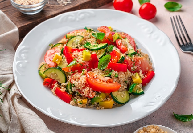 Healthy vegetable salad with quinoa and fresh herbs on a gray background Side view closeup