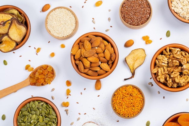 Healthy vegetarian food concept Assortment of dried fruits nuts and seeds on white background