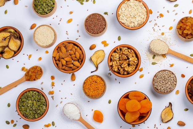 Healthy vegetarian food concept Assortment of dried fruits nuts and seeds on white background