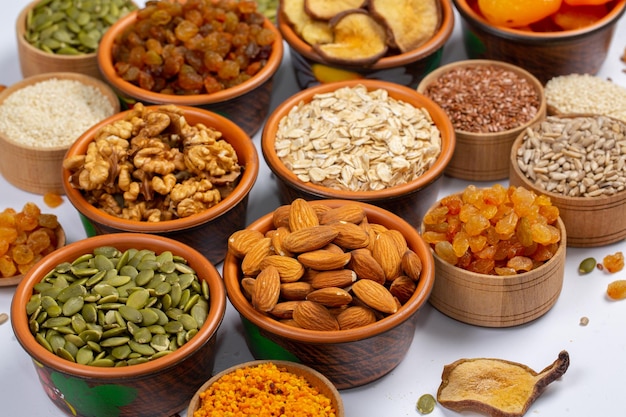 Healthy vegetarian food concept Assortment of dried fruits nuts and seeds on white background