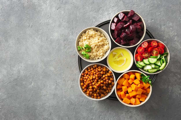 Healthy vegetarian ingredients for cooking moroccan salad. Chickpeas, Baked pumpkin and beets, quinoa and vegetables.