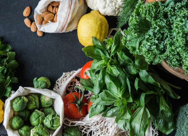 Healthy vegetarian  ingredients for cooking. Various clean vegetables, herbs, nut  on black background. Products from market without plastic. Flat lay. Copy space