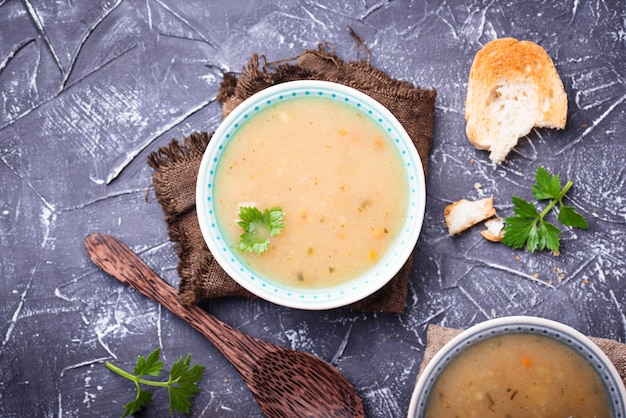 Healthy vegetarian peas soup on concrete background