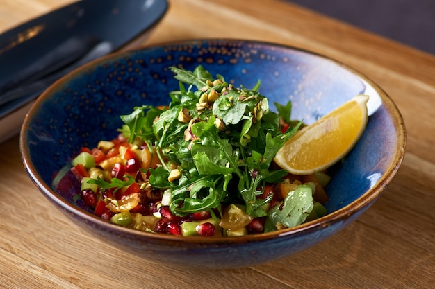 Healthy vegetarian salad avocado, pomegranate and sesame in plate on the table