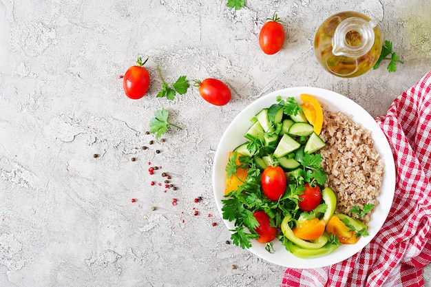 Healthy vegetarian salad of fresh vegetables, tomatoes, cucumber, sweet peppers and porridge