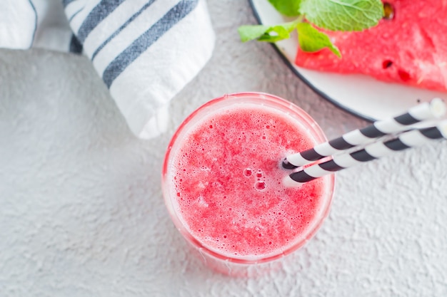 Healthy watermelon drink and fresh watermelon on light concrete background