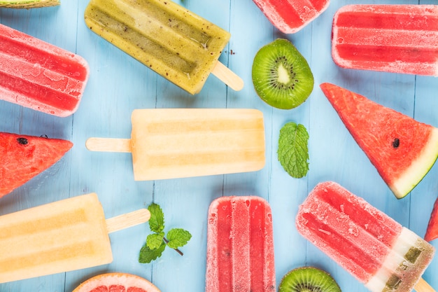 Healthy Whole Fruit Popsicles with Berries Kiwi watermelon cantaloupe on wooden vintage table