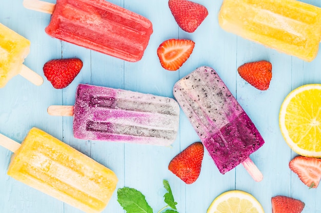 Healthy Whole Fruit Popsicles with Berries Strawberry orange  Dragon fruit  on wooden vintage table