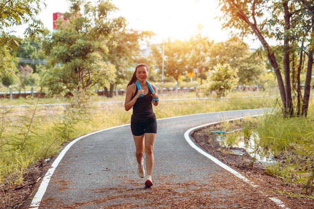 Healthy woman workouts in the park in summer