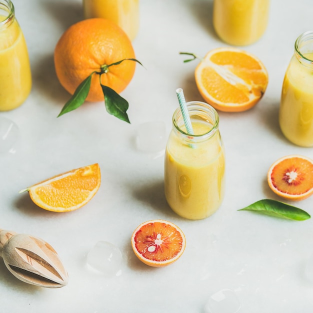 Healthy yellow smoothie with citrus fruit square crop