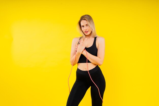 Photo healthy young woman skipping rope in studio muscular young female exercising with jumping rope