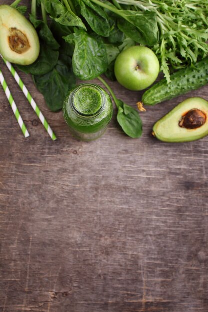 Healty green vegetable: spinach, cucumber, lettuce, apple and avocado on dark background. flat lay, copy space.