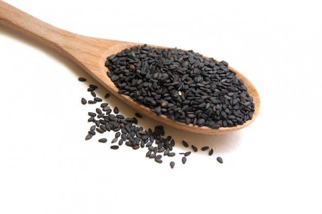 Heap black sesame seeds  close up shot on wooden spoon, isolated